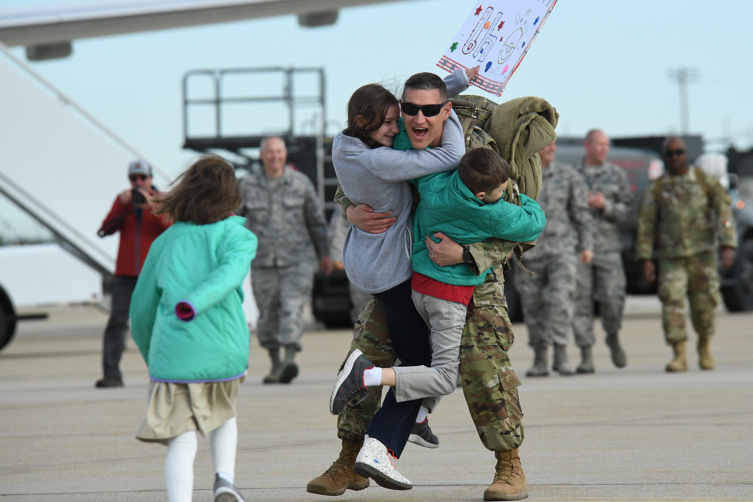 A joyful military homecoming with family hugs