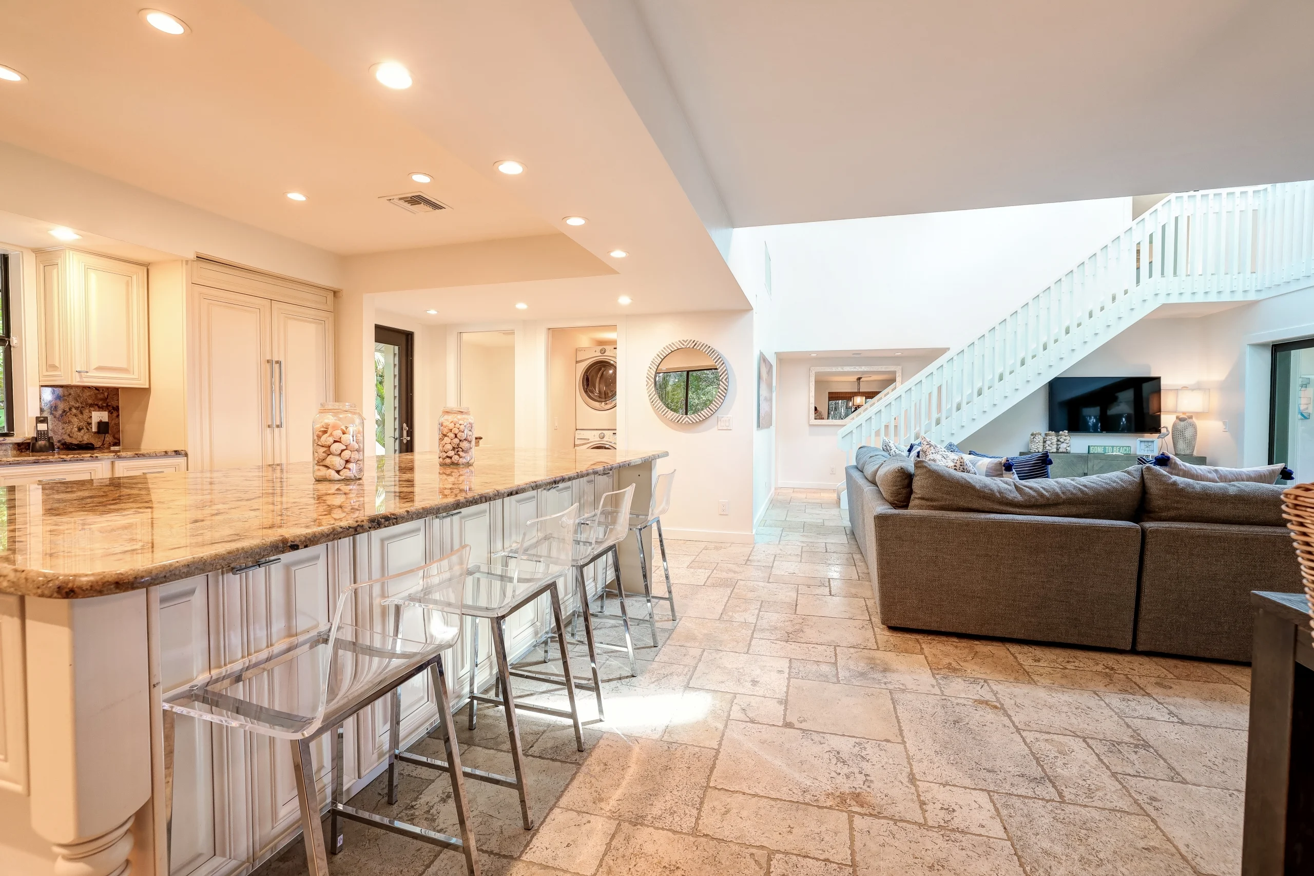 Open kitchen and living room with granite counter and gray sofa
