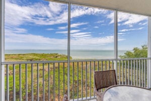 Screened balcony overlooking beach and ocean.