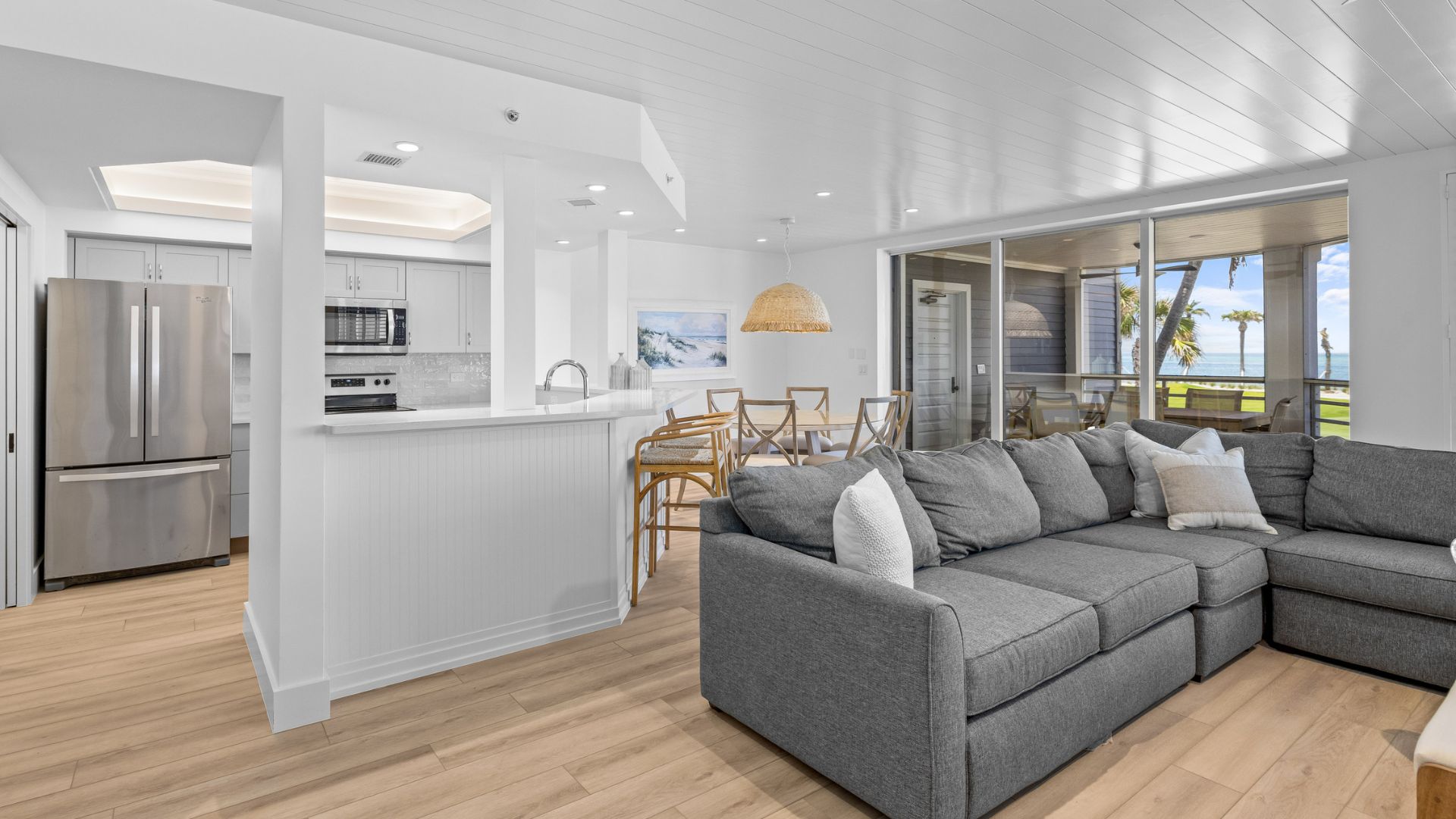 Modern condo with ocean views, a big sofa, and open kitchen