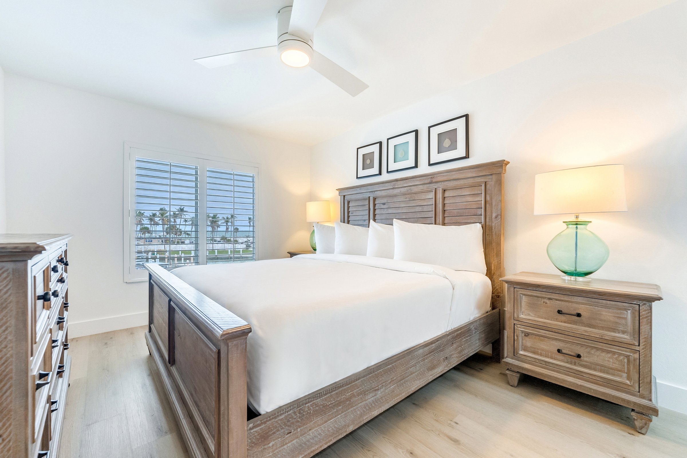 Bright bedroom with wooden bed two lamps and window view