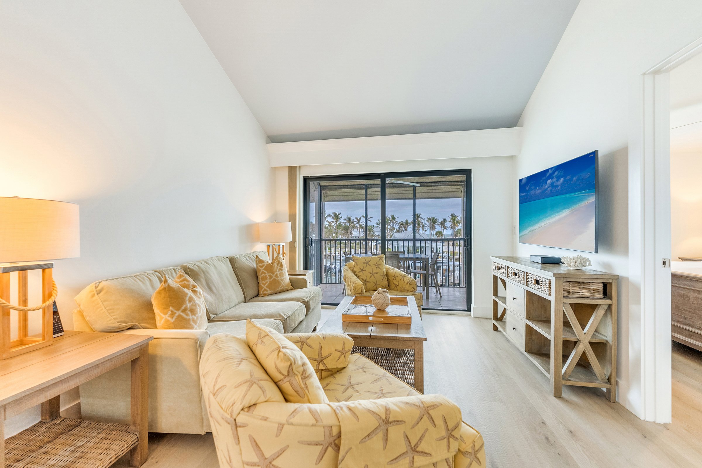 Living room with sofa chairs TV and balcony view