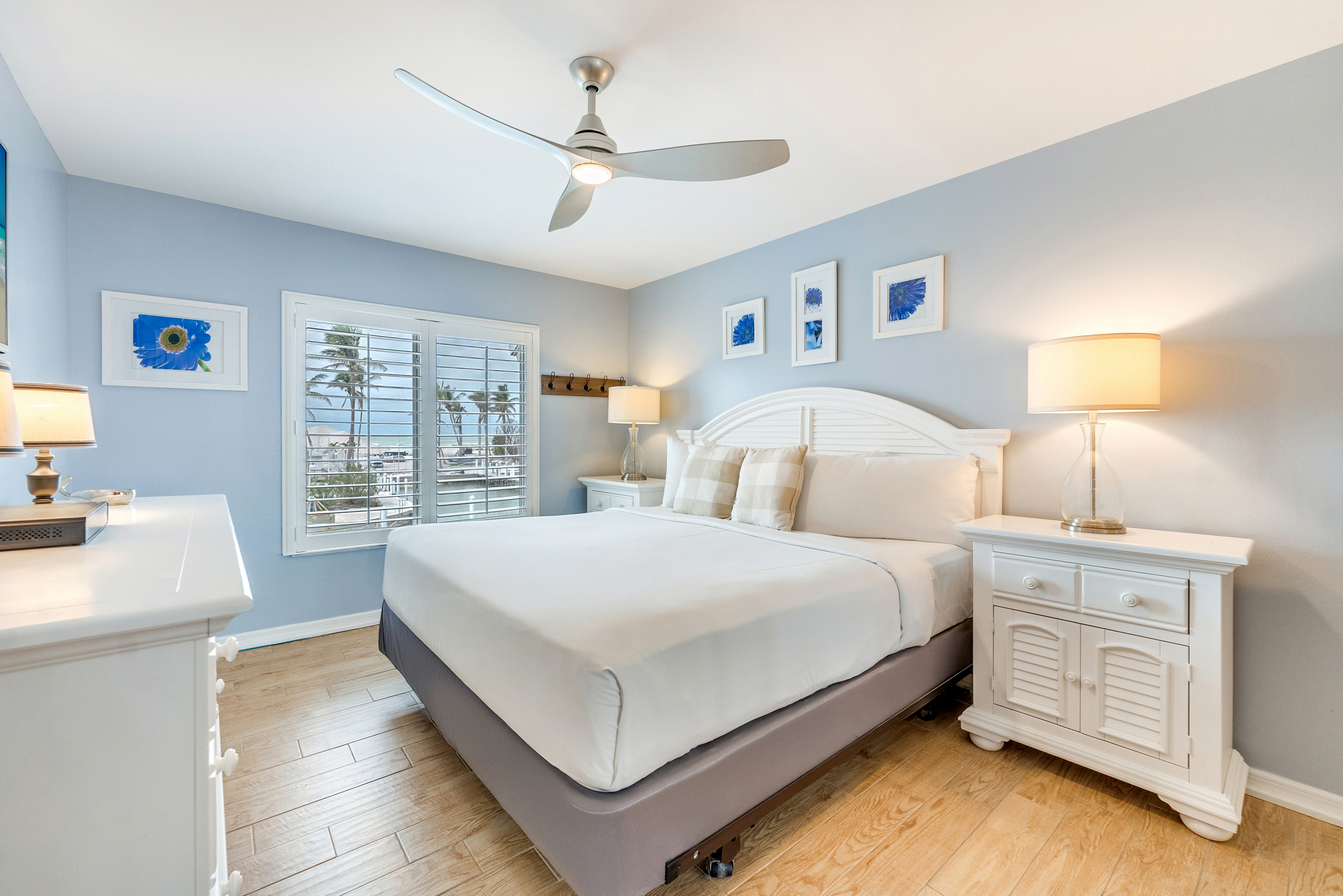 Bedroom with a blue wall, white furniture, and a ceiling fan