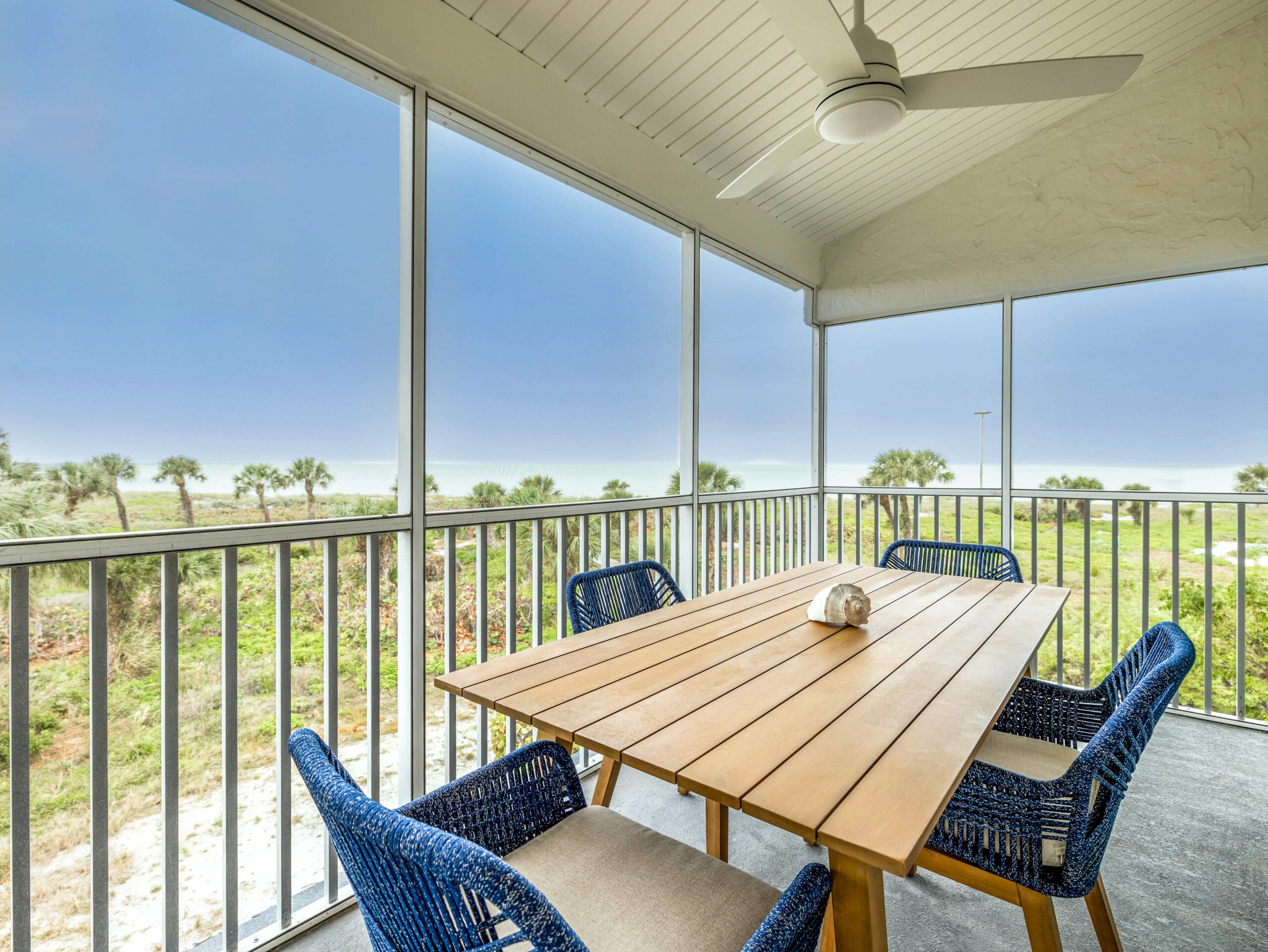 Balcony with table, chairs, and nature view.