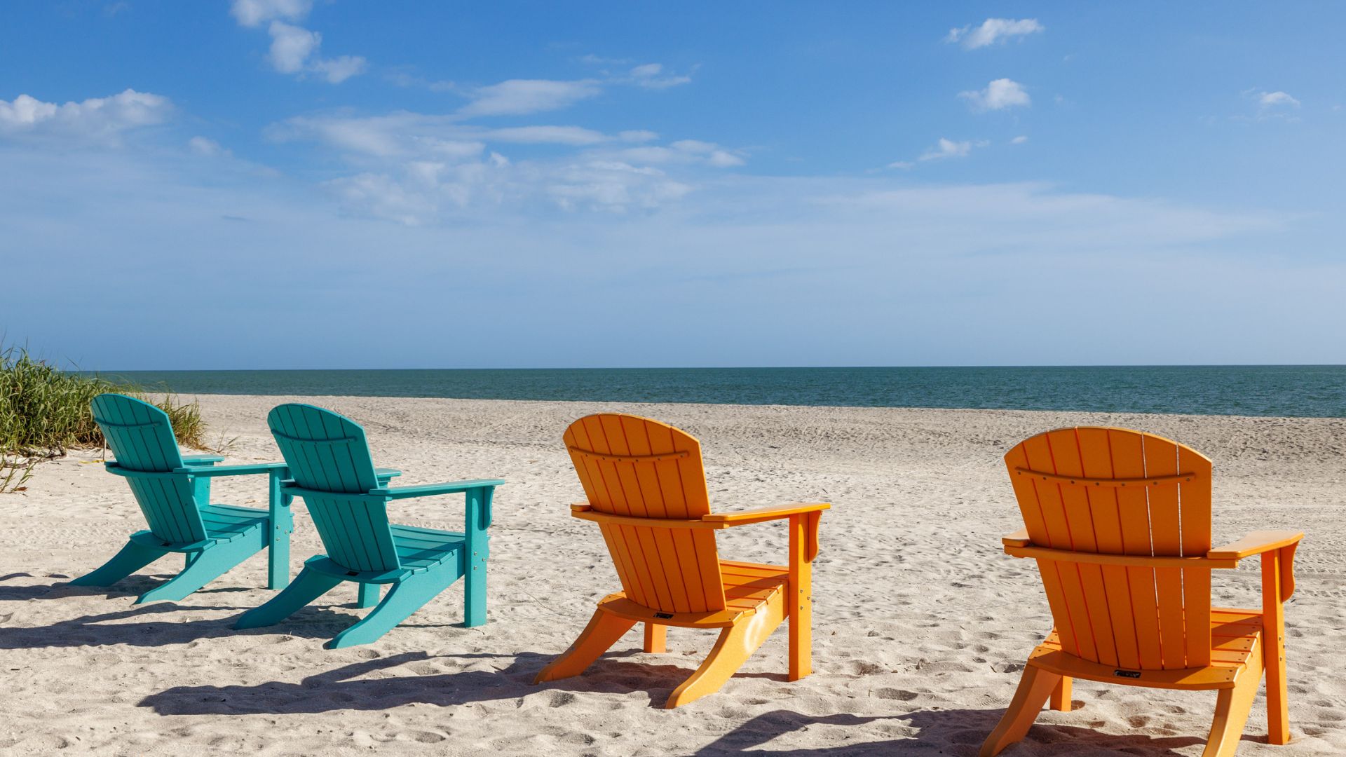 Empty colorful beach chairs facing the ocean