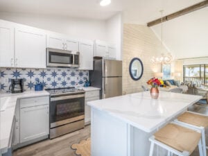 Bright kitchen with white cabinets and patterned blue tile