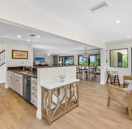 Open-concept space with kitchen, wooden floors, and dining area with large windows