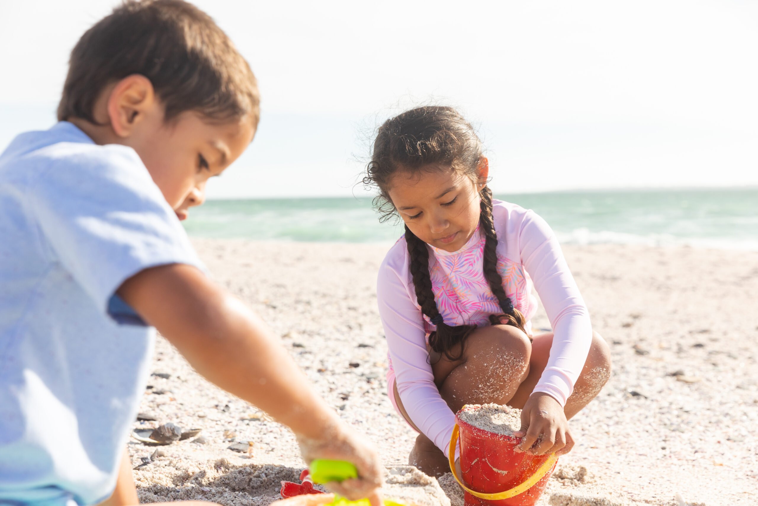 Children building sandcastles by the ocean