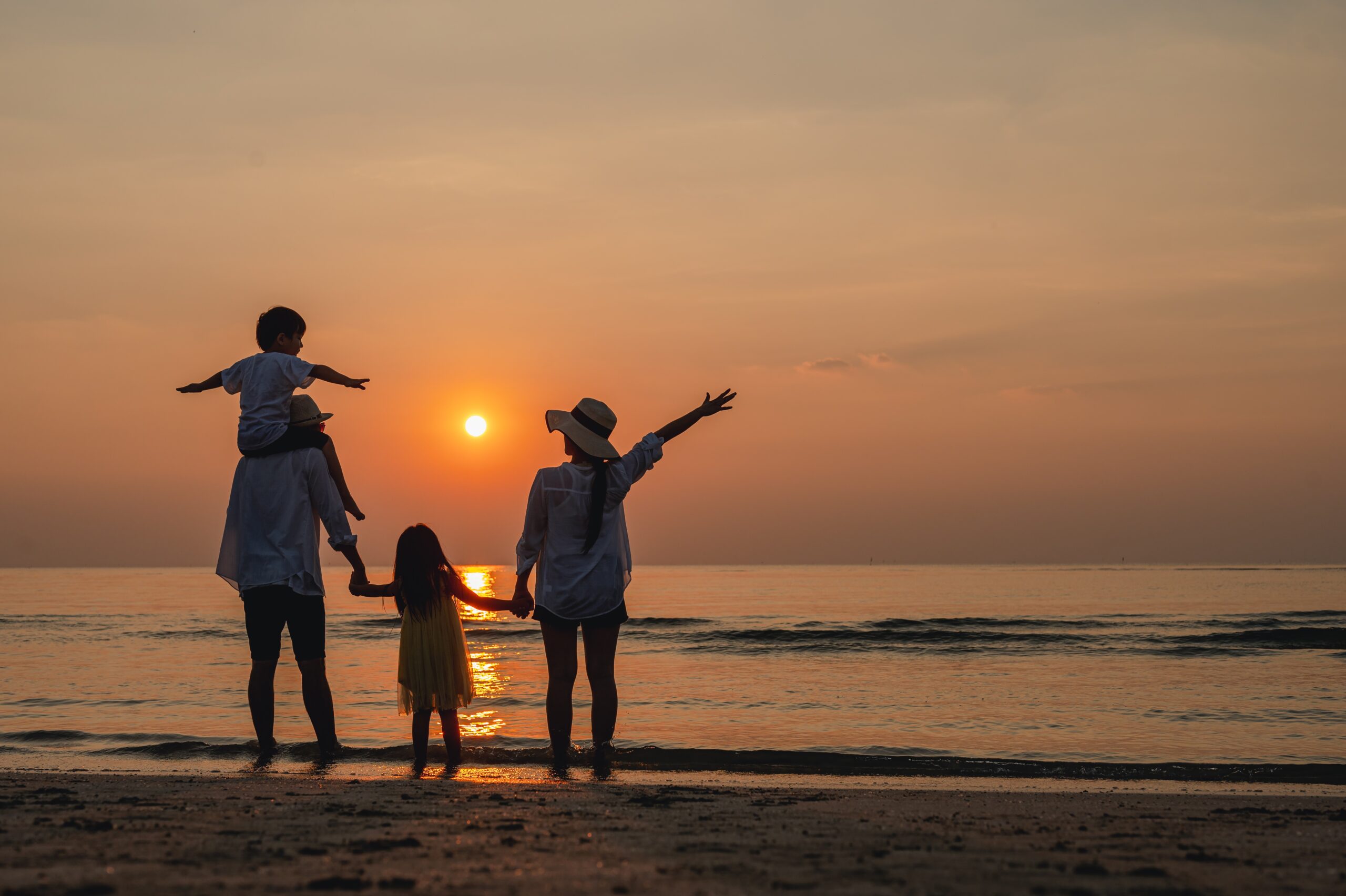 Happy family together on the beach in holiday. of the family holding hands enjoying the sunset on the beach.Summer,Family and vacations concept.