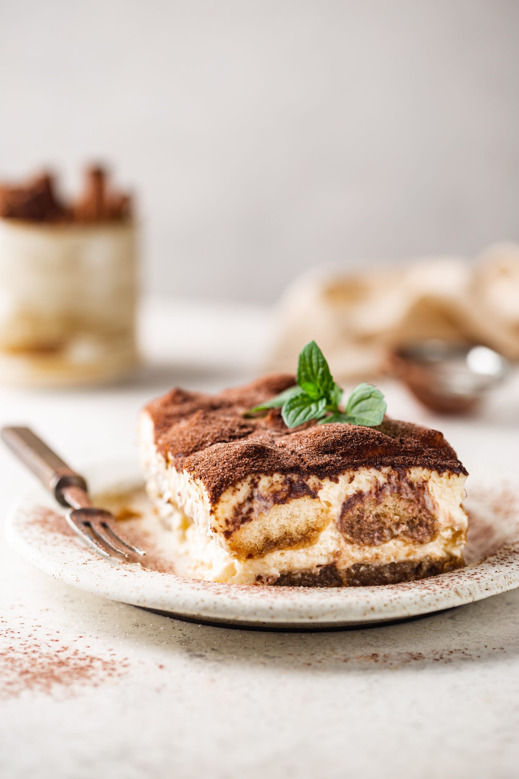 Piece of traditional Italian dessert tiramisu on white background